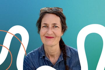 Simone Mani. Woman with braided hair and glasses on head, blue background.