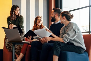Group of people smiling in a meeting room.