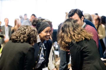 People in business attire conversing at a conference.