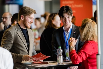 Three people talking at a business conference.